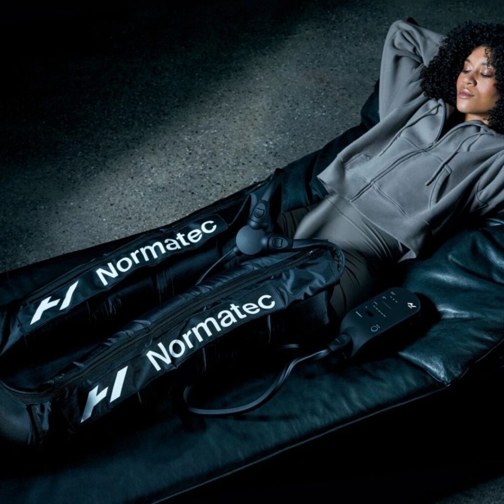 Woman using Normatec compression boots in Philadelphia PA